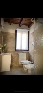een badkamer met een toilet, een wastafel en een raam bij Casa Mia Maria Margot LODI Self check in in Lodi