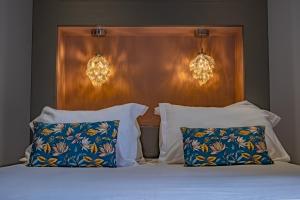 sypialnia z łóżkiem z 2 poduszkami i 2 światłami w obiekcie La Maison Rouge w mieście Barberaz