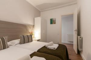 um quarto com uma grande cama branca e uma janela em Aribau em Barcelona