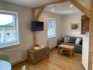 a living room with a couch and a tv at Panoramahotel Lilienstein in Königstein an der Elbe