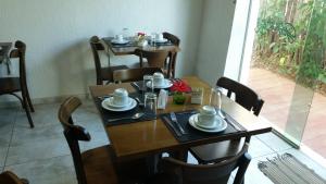 una mesa de madera con platos y tazas. en Pousada da Germana en Fernando de Noronha