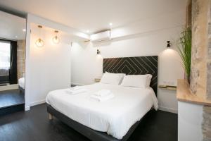 1 dormitorio con 1 cama grande con sábanas blancas en L' échafaud - Apparts de standing - Centre historique, en Périgueux