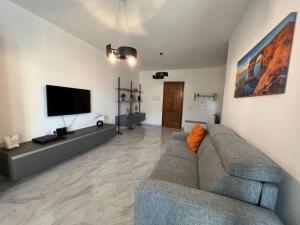 a living room with a couch and a flat screen tv at Gozo - 3 Bedroom - Brand New in Żebbuġ