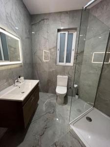 La salle de bains est pourvue d'un lavabo, de toilettes et d'une douche. dans l'établissement Gozo - 3 Bedroom - Brand New, à Żebbuġ