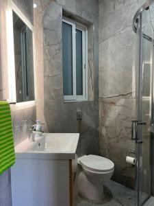 La salle de bains est pourvue d'un lavabo, de toilettes et d'un miroir. dans l'établissement Gozo - 3 Bedroom - Brand New, à Żebbuġ