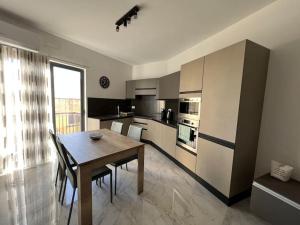 une cuisine avec une table en bois et une salle à manger dans l'établissement Gozo - 3 Bedroom - Brand New, à Żebbuġ