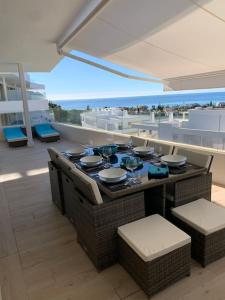 stół i krzesła na balkonie z widokiem na ocean w obiekcie Prachtig appartement met zeezicht in Estepona Costa del Sol w mieście Estepona
