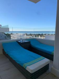 two beds on a balcony with a view of the beach at Prachtig appartement met zeezicht in Estepona Costa del Sol in Estepona