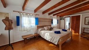a bedroom with a bed and a table with a lamp at Can Toni Blay in Es Calo