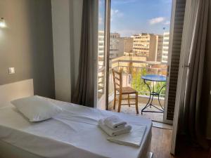 1 dormitorio con 1 cama y balcón con vistas. en Sparta Team Hotel en Athens