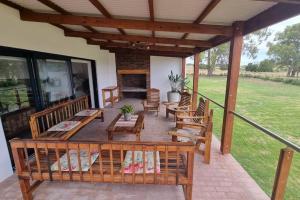 a patio with wooden benches and a table and chairs at Bestuis Cottage - Self catering accommodation on a farm in Klapmuts
