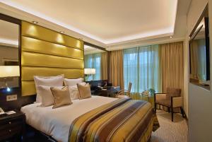 a hotel room with a large bed and a desk at Park Grand Mayfair in London +36 photos