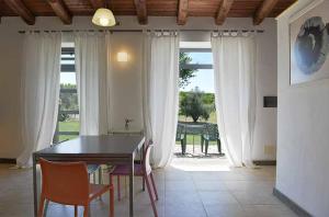 ein Esszimmer mit einem Tisch, Stühlen und einem Fenster in der Unterkunft Agriturismo Arte et Agricoltura in Tuscania