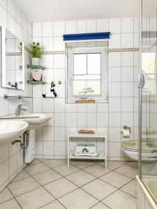 baño con 2 lavabos, aseo y ventana en Gollwitzer Park Seesternchen, en Poel