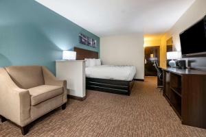 um quarto de hotel com uma cama e uma cadeira em Sleep Inn Jacksonville Airport em Jacksonville