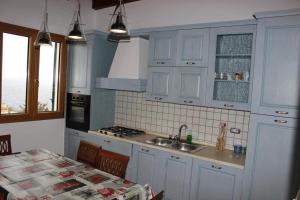 a kitchen with white cabinets and a sink and a table at Suite Vista Mare in Santa Cesarea Terme
