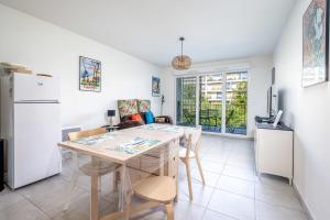 - une cuisine et une salle à manger avec une table et des chaises dans l'établissement Air-conditioned flat with terrace garage and close to beaches, à Cannes