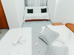 1 dormitorio con 1 cama blanca en Apartmani Dragobratović, en Komarna