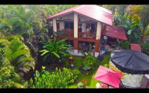 eine Aussicht auf ein Haus mit einem rosa Regenschirm in der Unterkunft Phoenix Garden in Pahoa
