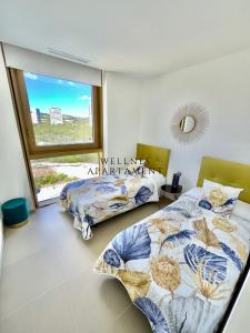 1 Schlafzimmer mit 2 Betten und einem großen Fenster in der Unterkunft INTEMPO Sky Wellness Apartament in Benidorm