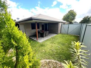 uma casa com uma cerca num quintal em Bundys Best! Modern Luxury in the heart of town em Bundaberg