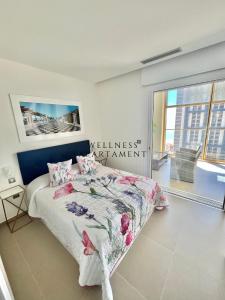 ein Schlafzimmer mit einem Bett und ein Schild, das Wellness-Management liest in der Unterkunft INTEMPO Sky Wellness Apartament in Benidorm