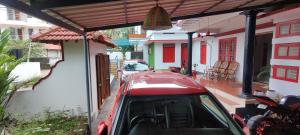 a red car parked in front of a house at RED LION in Varkala