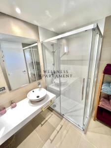 ein Bad mit einer Dusche und einem Waschbecken in der Unterkunft INTEMPO Sky Wellness Apartament in Benidorm