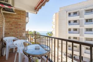 ein Balkon mit Tisch und Stühlen und Blick auf das Meer in der Unterkunft Bahia 327 in Nerja