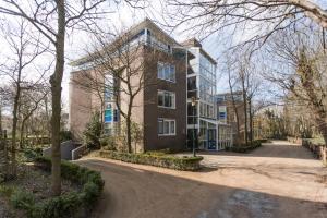 a large brick building with a road in front of it at Hello Zeeland - Appartement Loverendale 31 in Domburg
