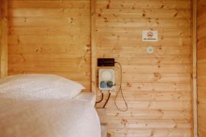 シュピールベルクにあるEvent Lodge Camping Spielbergの木製の壁のベッド1台が備わる小さな客室です。
