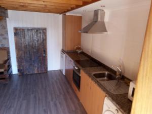 a kitchen with a sink and a stove at Casa da Porta velha in São Gião
