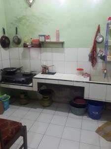 a kitchen with white tiled floors and a counter top at PRB Homestay in Pilang