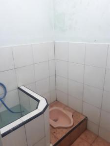 a bathroom with a toilet in a tiled room at PRB Homestay in Pilang