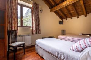 a bedroom with two beds and a window at Posada 3 Valles in Liérganes