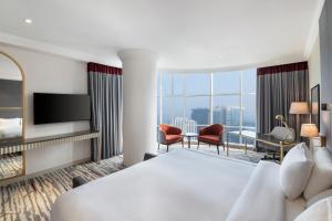 ドーハにあるRamada by Wyndham Doha Old Townのベッドと大きな窓があるホテルの部屋 +26枚の写真