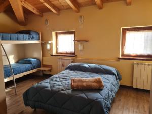a bedroom with two bunk beds and two windows at Foresteria Giardino in Paisco