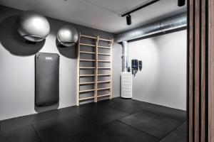 una habitación con un gimnasio con una pared con estanterías y pesas en Go Hotel Østerport, en Copenhague