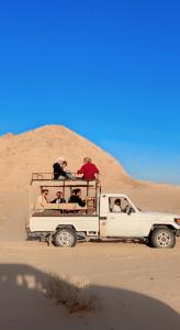 a group of people in a white truck in the desert at Nael Bedouin camp in Wadi Rum