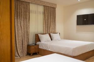 Habitación de hotel con 2 camas y TV en El Mina City, en ‘Izbat al Burj