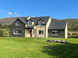 a house with a green lawn in front of it at Valentia View Holiday Home in Cahersiveen