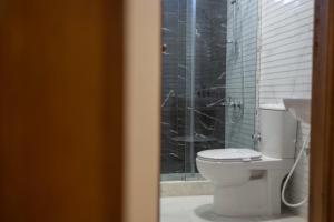 W łazience znajduje się toaleta i przeszklony prysznic. w obiekcie El Mina City w mieście ‘Izbat al Burj