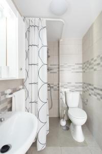 a white bathroom with a toilet and a sink at Home2Book Comfy Seaside Apartment Cristimar, Pool in Los Cristianos