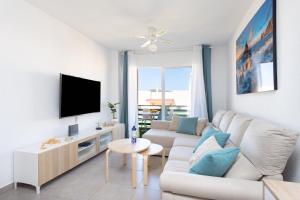 a living room with a couch and a tv at Home2Book Comfy Seaside Apartment Cristimar, Pool in Los Cristianos