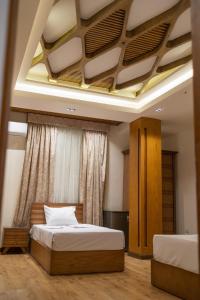 sypialnia z 2 łóżkami i kasetonowym sufitem w obiekcie El Mina City w mieście ‘Izbat al Burj