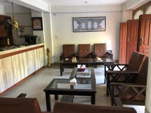 a living room with tables and chairs and a counter at The Hotel in Bandīpur
