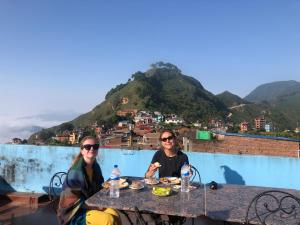 een man en vrouw aan een tafel met eten bij The Hotel in Bandipur