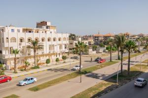 una vista aérea de una calle con palmeras y coches en El Mina City, en ‘Izbat al Burj