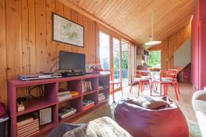 a living room with a television and a table with chairs at Casa da Piscina - Casas de Alem - Ecoturismo in Arcos de Valdevez