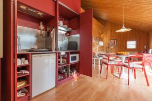 eine Küche und ein Esszimmer mit roten Wänden und einem Tisch in der Unterkunft GoToGeres - Casa da Piscina - Casas de Alem in Arcos de Valdevez + 21 Fotos